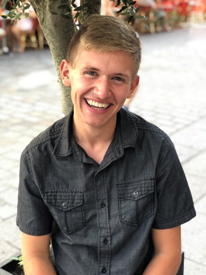 A person smiling for the camera Description automatically generated