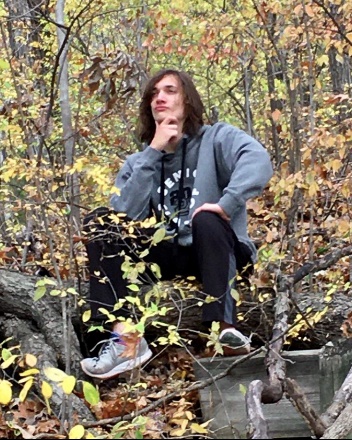 A person sitting on a log

Description automatically generated with low confidence