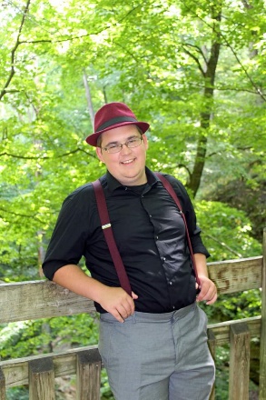 A person wearing a hat and suspenders

Description automatically generated